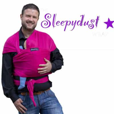white man wearing a baby in The Slepeydust Wrap Sweet Paradise with white background and Sleepydust logo